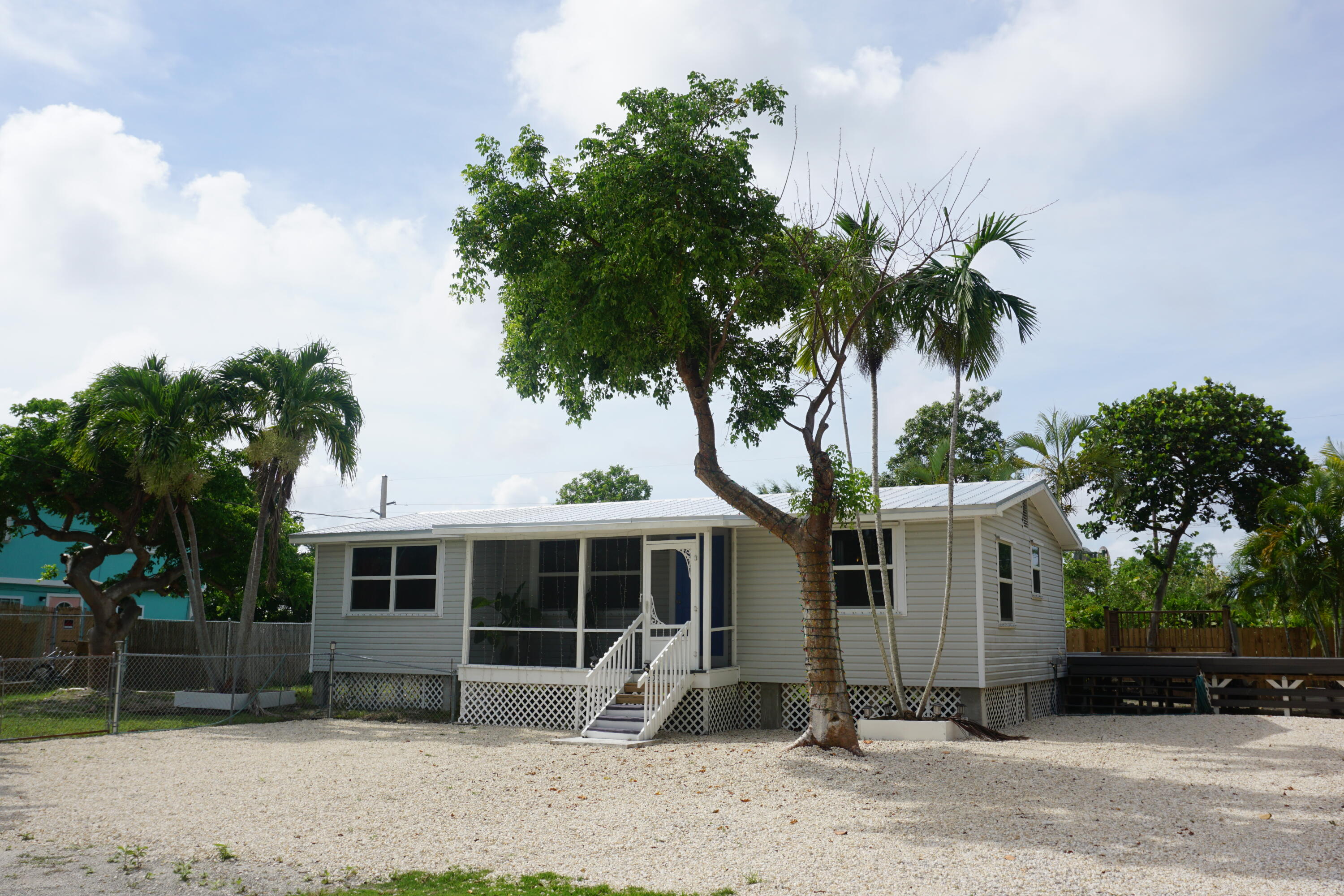 a front view of a house with garden and trees