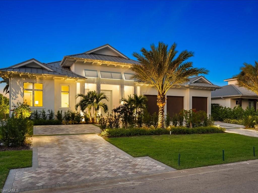 View of front facade featuring a front yard and a garage