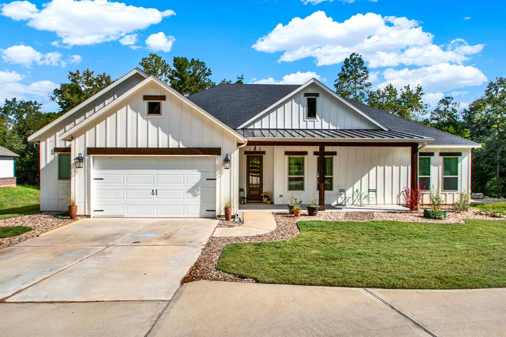 This is a charming single-story home featuring a modern farmhouse design with an oversized 2.5 car garage, and a welcoming front entrance. The well-manicured lawn adds to the home's curb appeal.