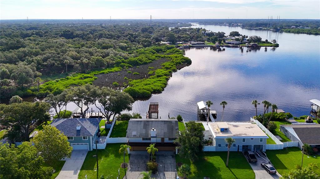 an aerial view of a house with a yard and lake view