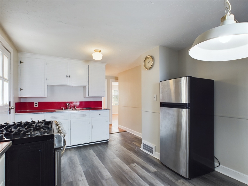 a kitchen with a refrigerator and a stove top oven