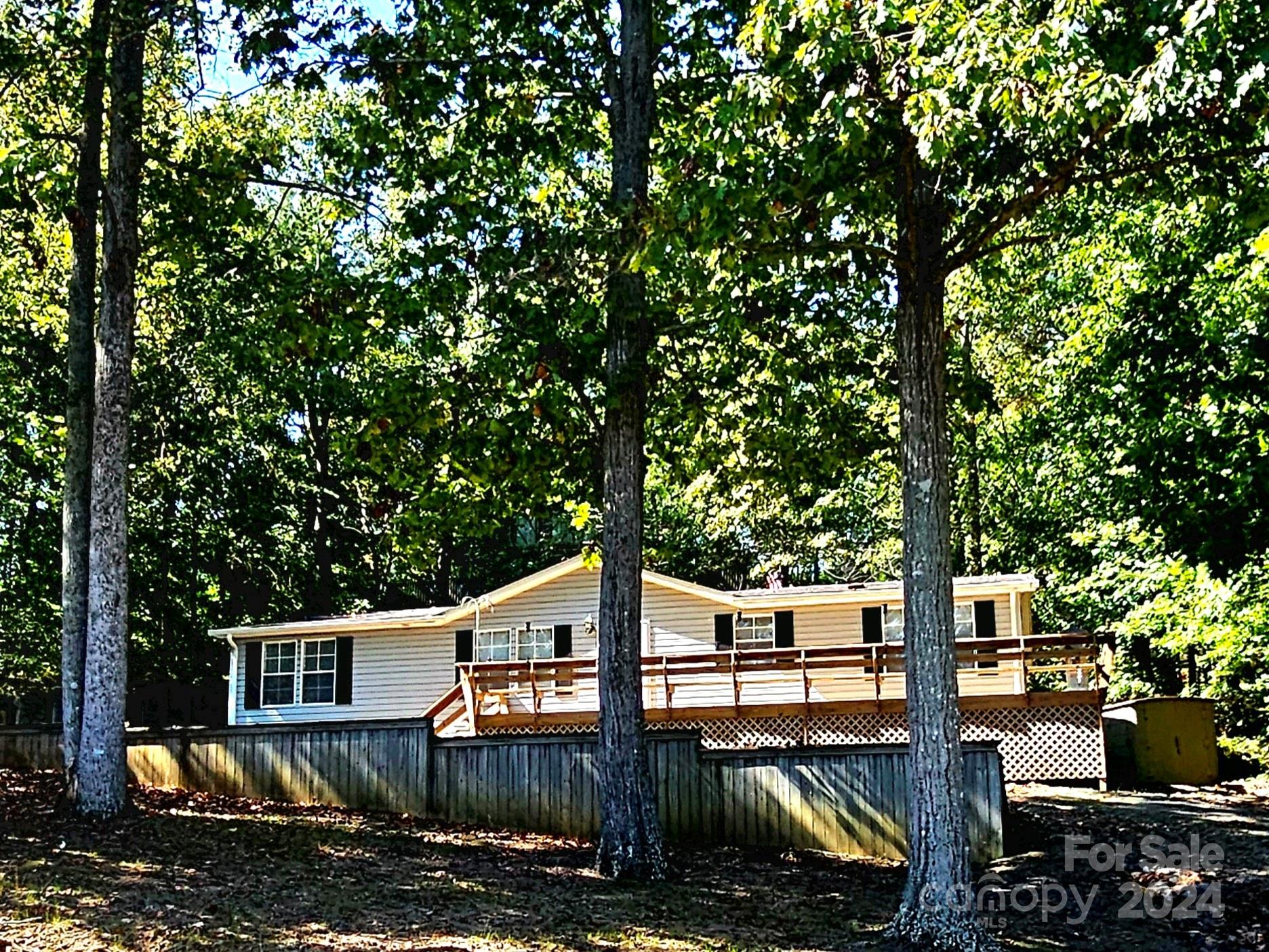 a front view of a house with trees and plants