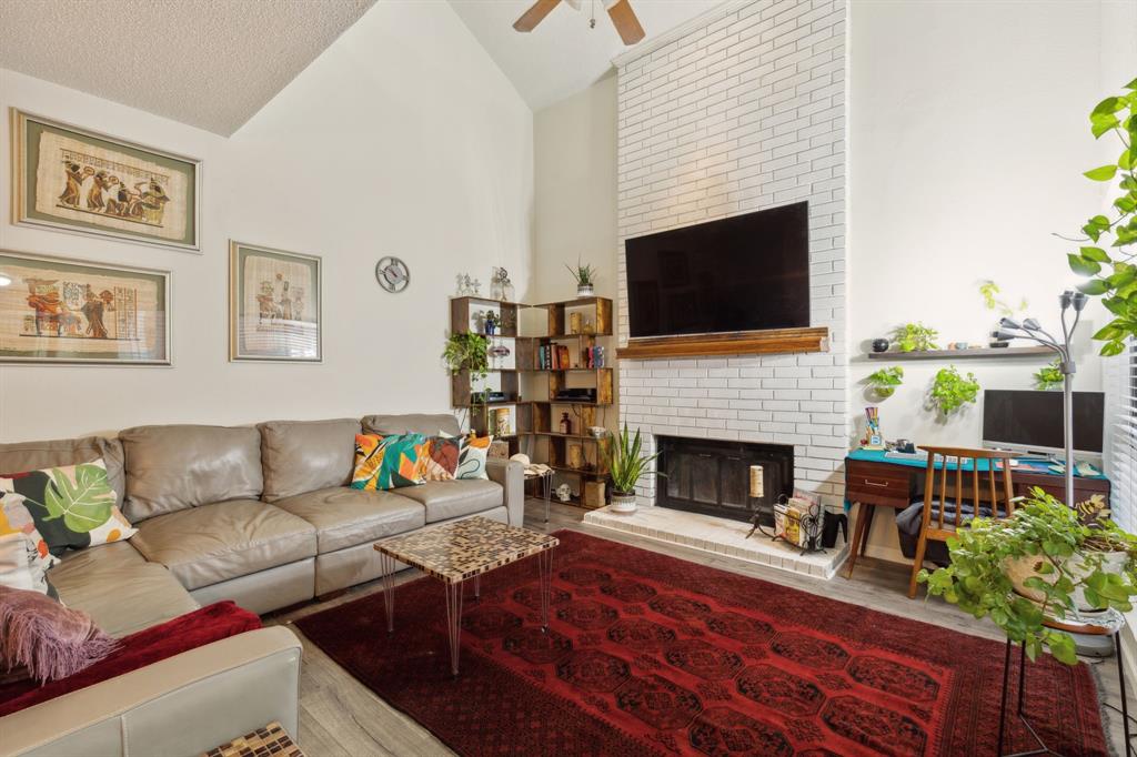 a living room with furniture a flat screen tv and a fireplace