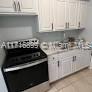 a kitchen with a stove and white cabinets