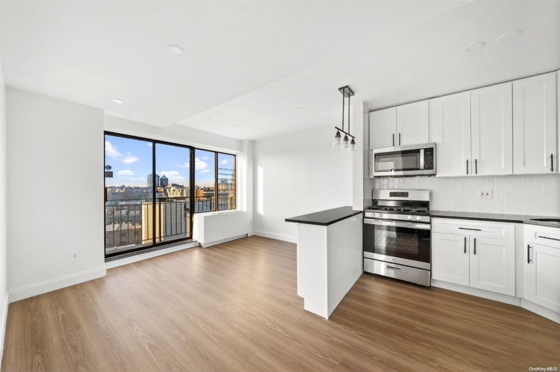 a kitchen with granite countertop a stove a sink and a refrigerator