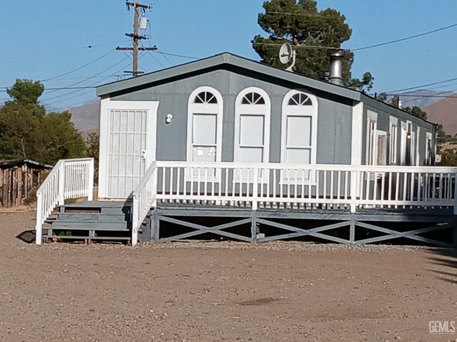 a view of a house with a deck and a yard