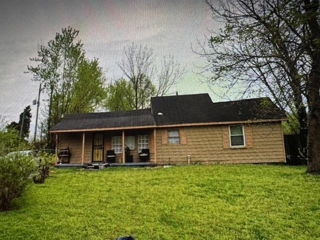 Rear view of property featuring a lawn