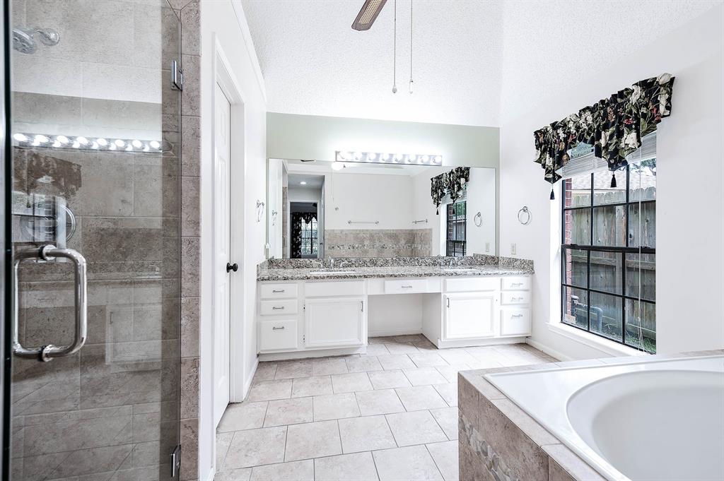 a bathroom with a granite countertop sink mirror and shower