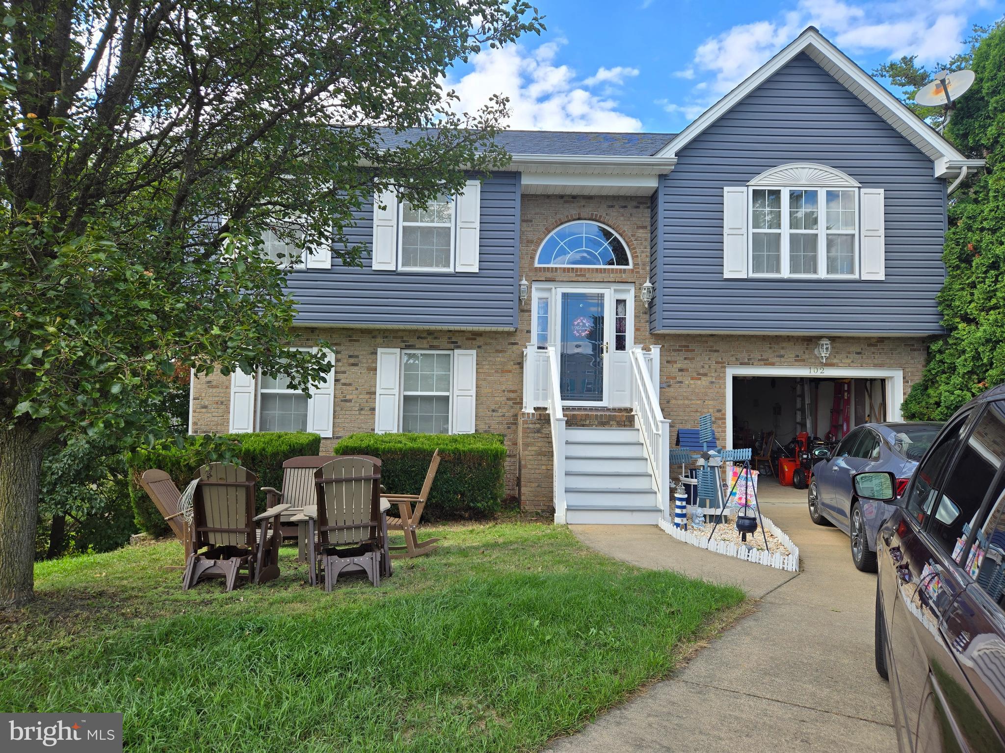 a front view of a house with outdoor seating and a garden