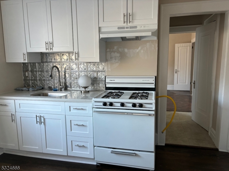 a kitchen with white cabinets and appliances