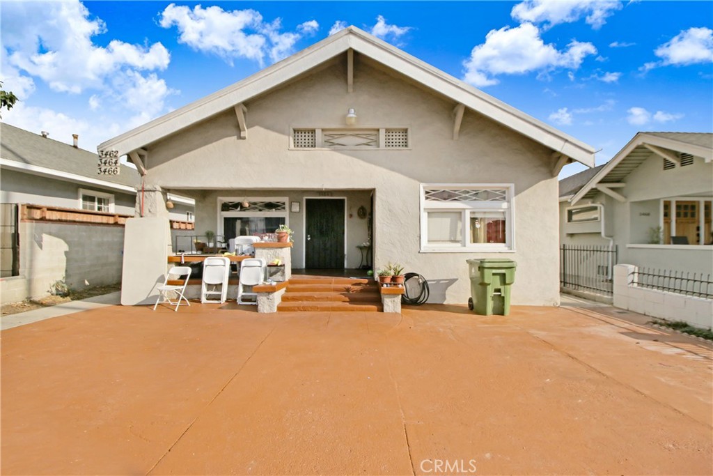 a view of a house with chairs and tables in patio