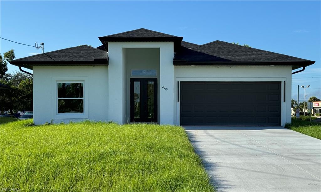 a front view of a house with a yard and garage