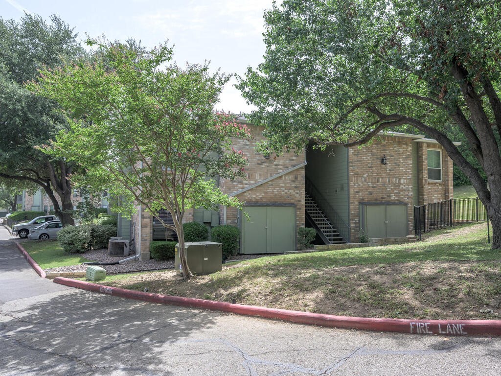 a backyard of a house with large trees and plants