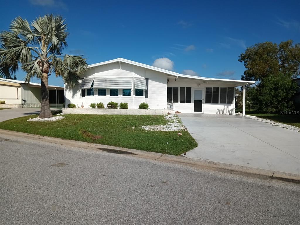 a front view of a house with a garden and trees