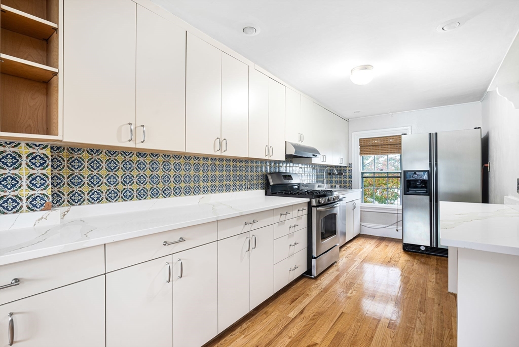 a kitchen with granite countertop white cabinets and white appliances