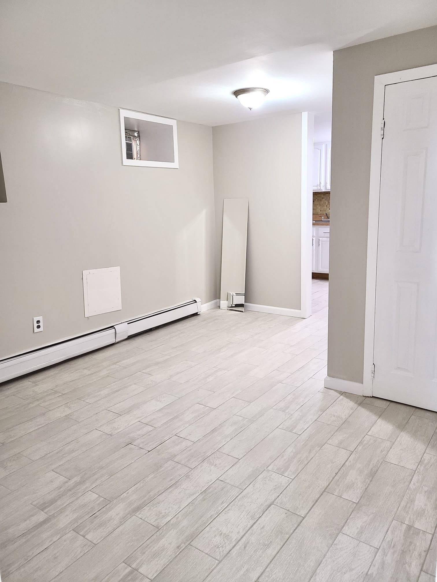 an empty room with wooden floor and white walls