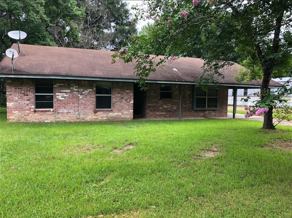 a front view of a house with a garden and yard