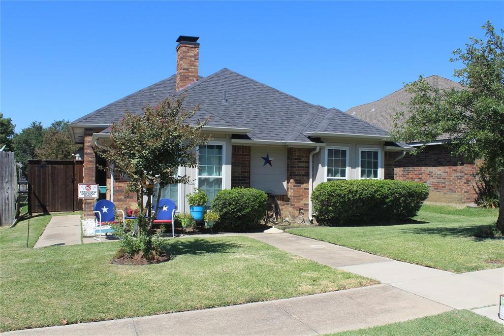 a front view of a house with a yard and potted plants