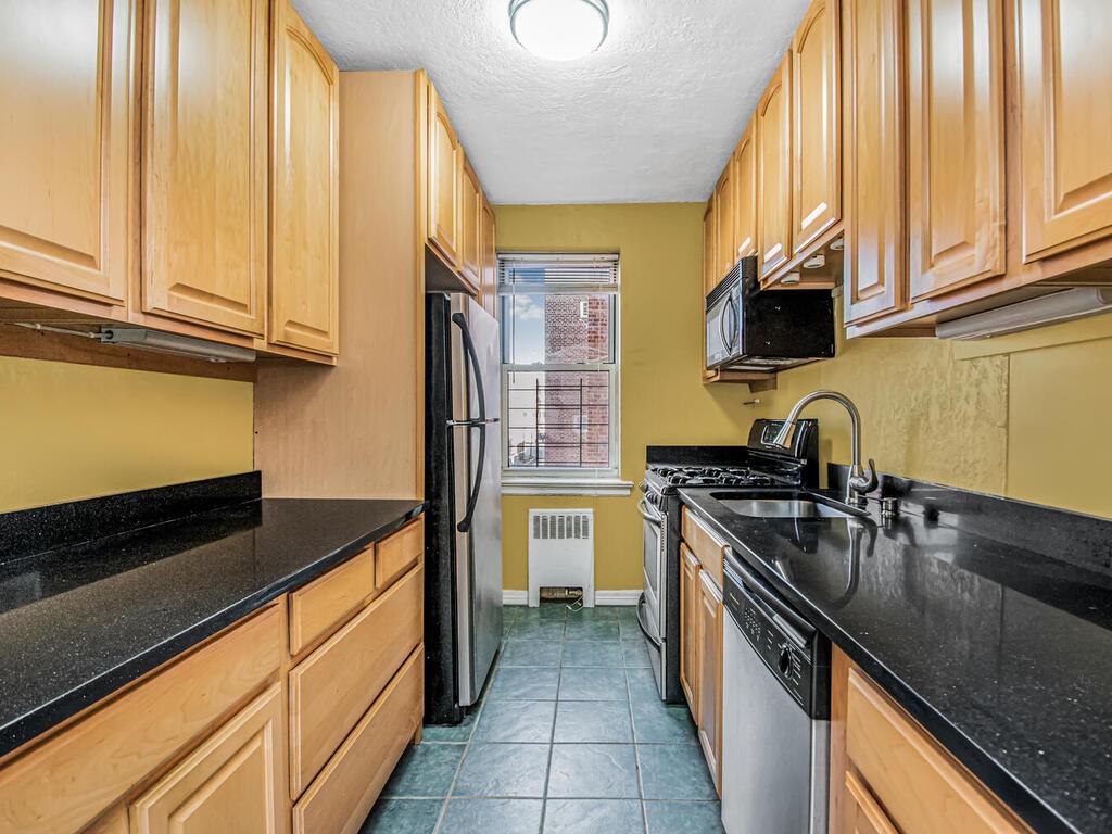 a kitchen with stainless steel appliances granite countertop a stove a sink and a microwave