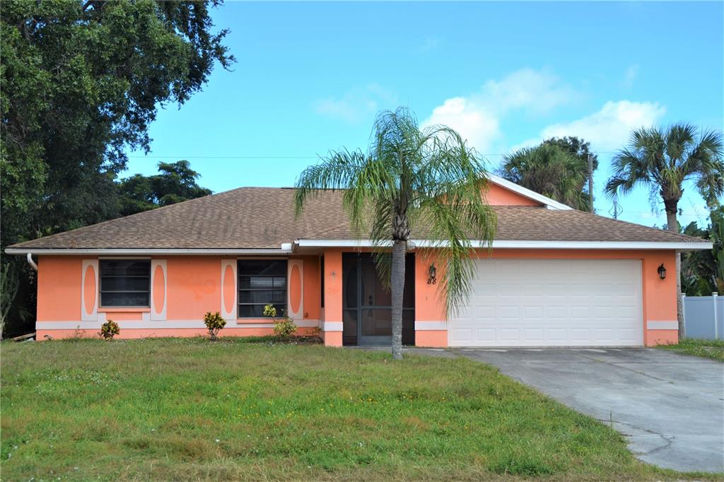 a front view of house with yard and trees in the background