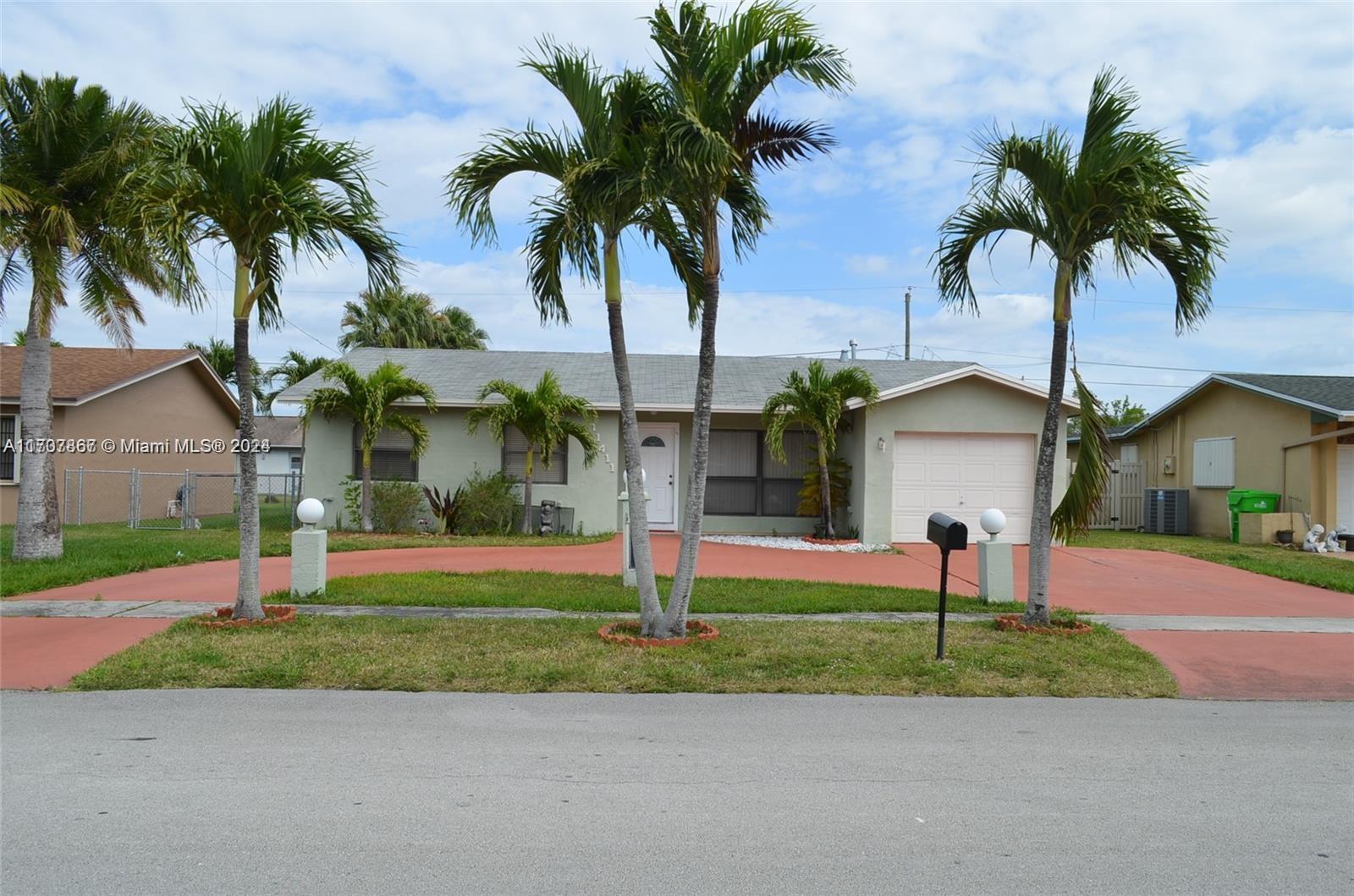 a palm tree sitting in front of a house with a yard