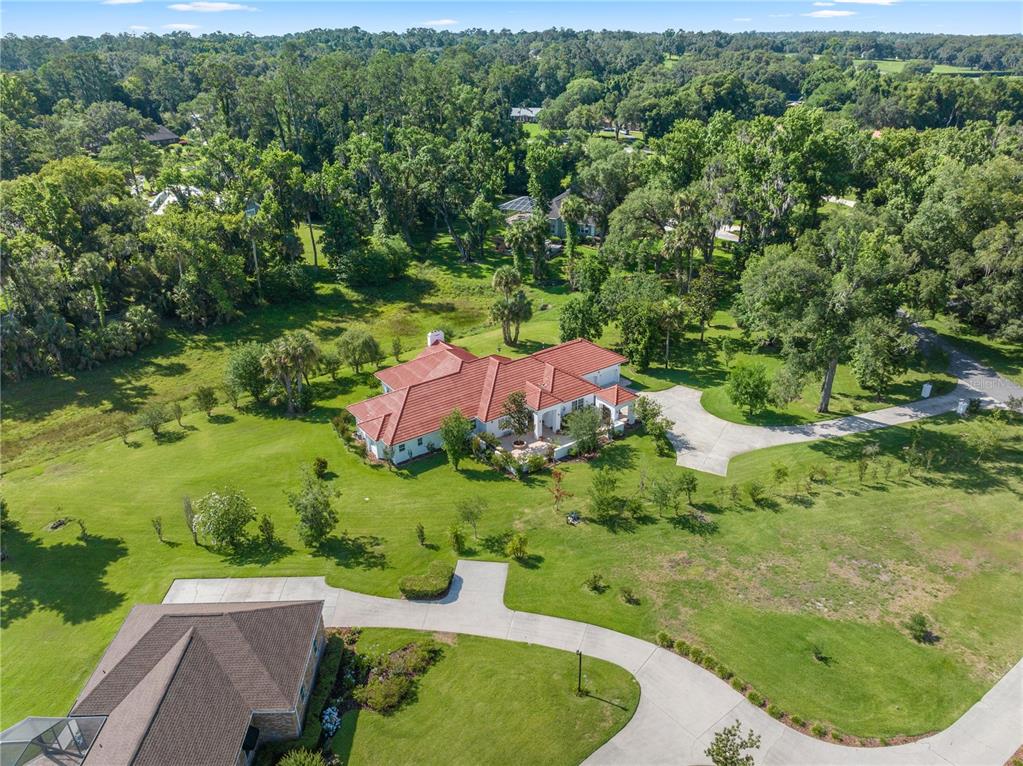 an aerial view of a house with a yard and outdoor seating