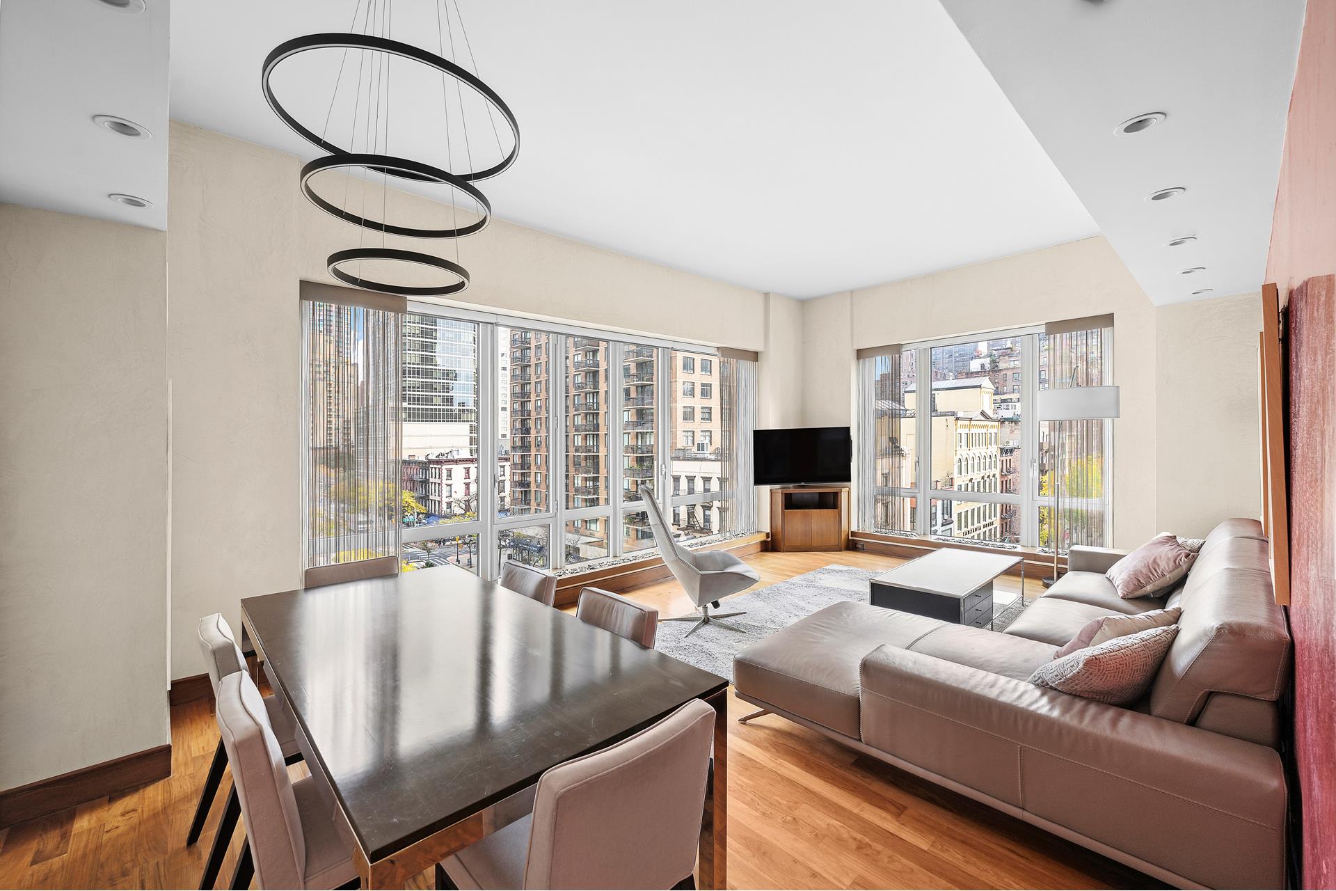 a living room with furniture a large window and a chandelier