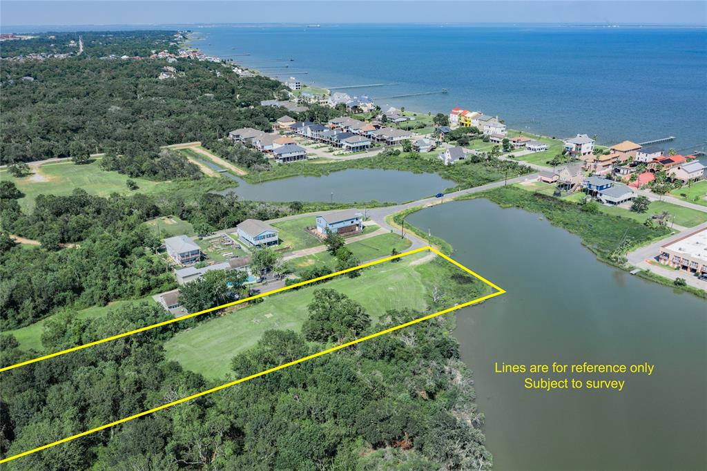 This aerial photo showcases a spacious waterfront property with outlined boundaries, nestled in a serene neighborhood near other homes and green spaces, with close proximity to the lake and Glavestion Bay.