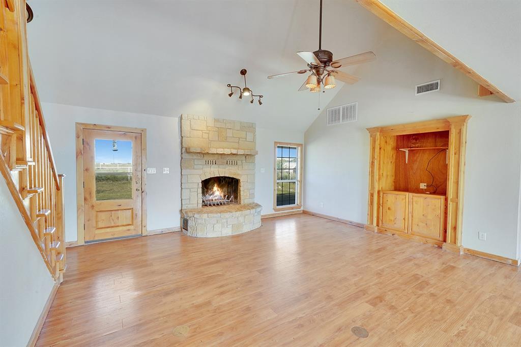 a view of an empty room with a fireplace and a window