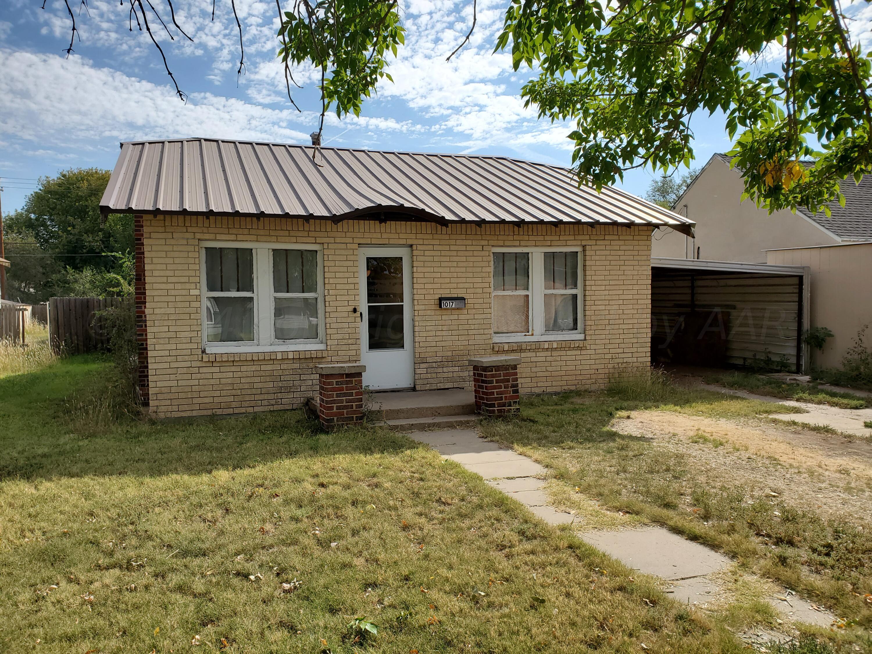 a view of a house with a yard and wooden fence