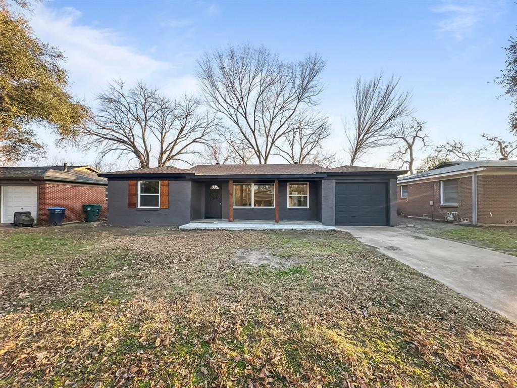 Single story home featuring a garage, a front yard, and a porch