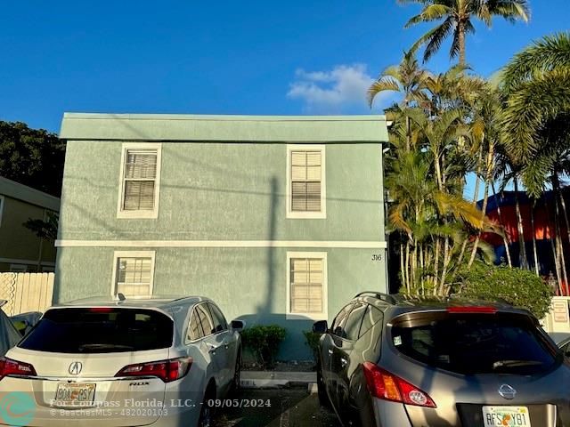 a couple of cars parked in front of a house