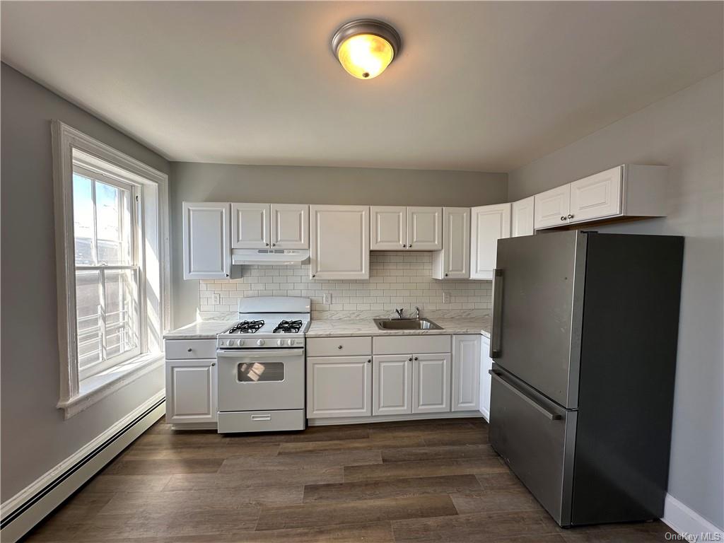 a kitchen with a white cabinets and refrigerator