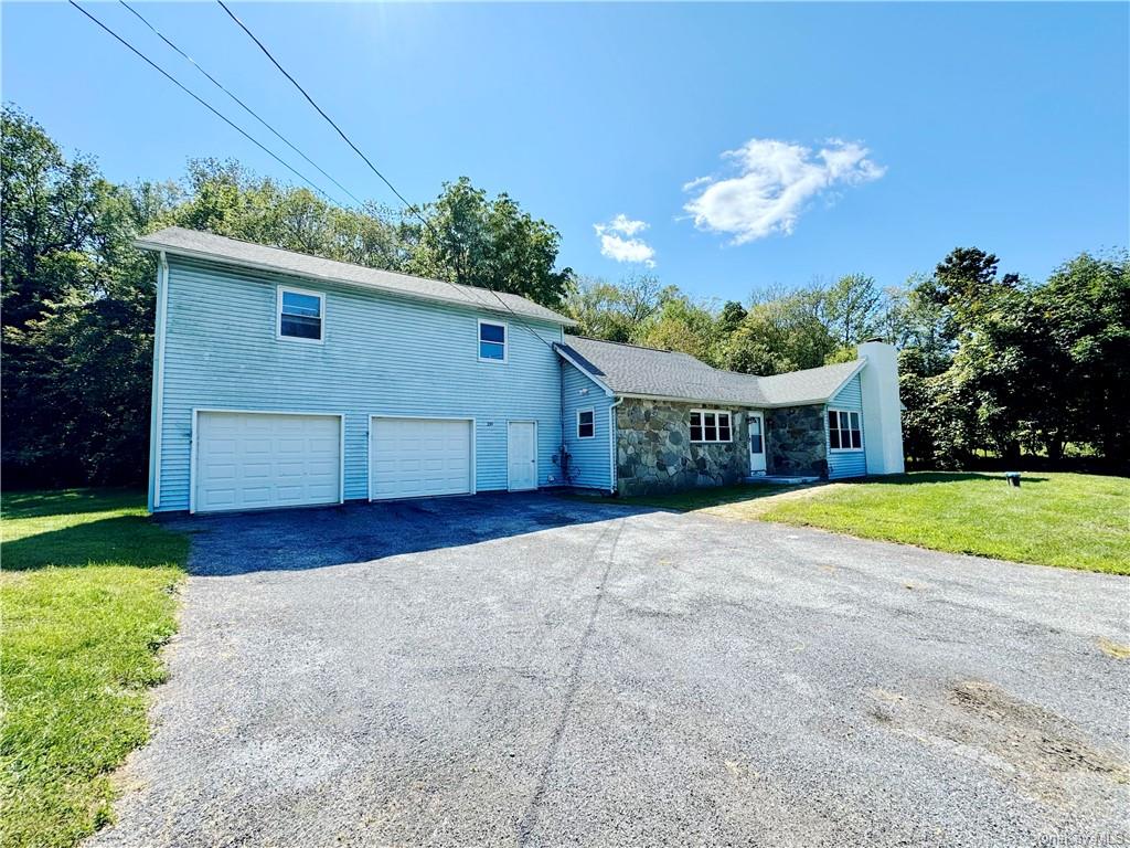 View of front of home with a front yard and a garage