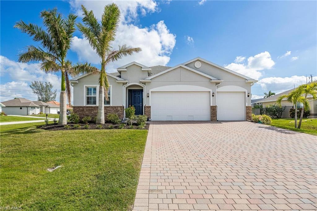 View of front of property featuring a garage and a front lawn