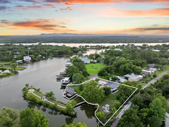 an aerial view of residential houses with outdoor space and ocean view