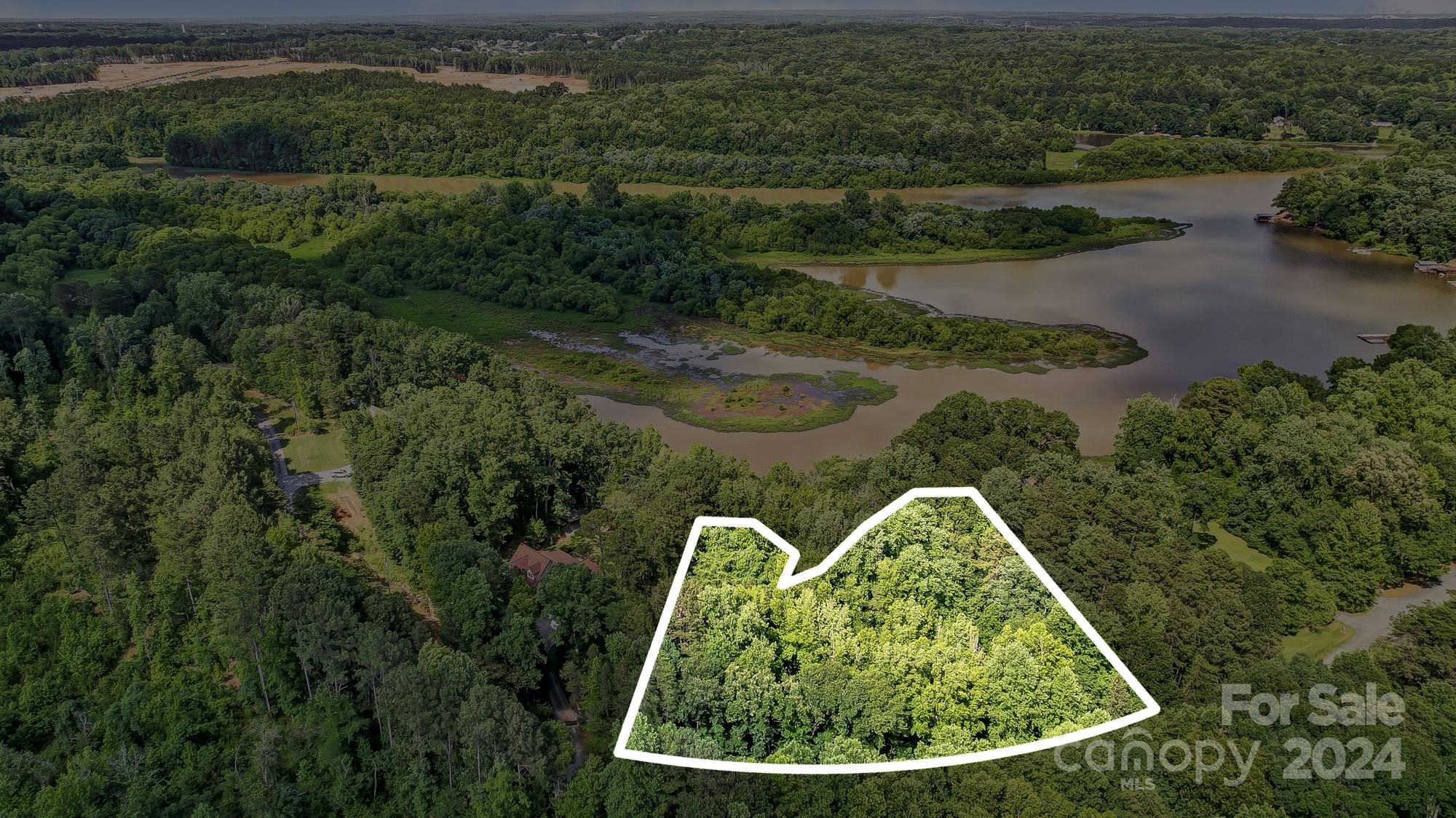 an aerial view of a house with outdoor space and lake view