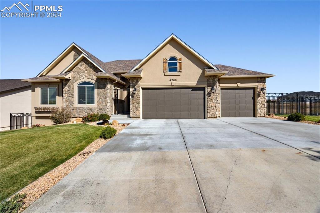 View of front facade featuring a front lawn and a garage