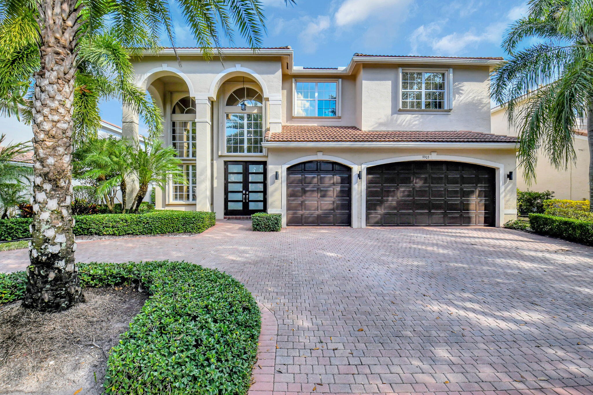 a front view of a house with yard and parking