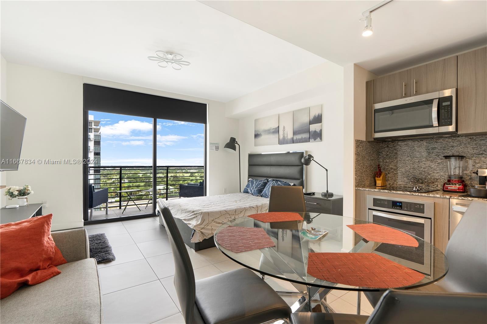 a living room with furniture a flat screen tv and floor to ceiling window