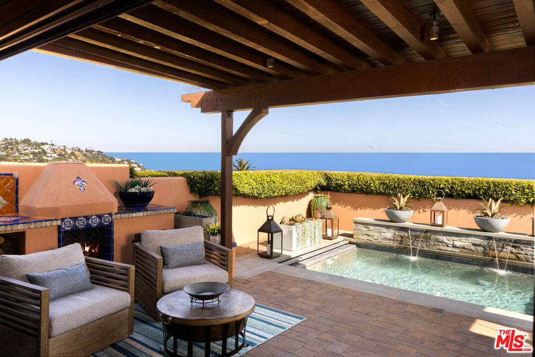 an outdoor living room with patio furniture and a rug