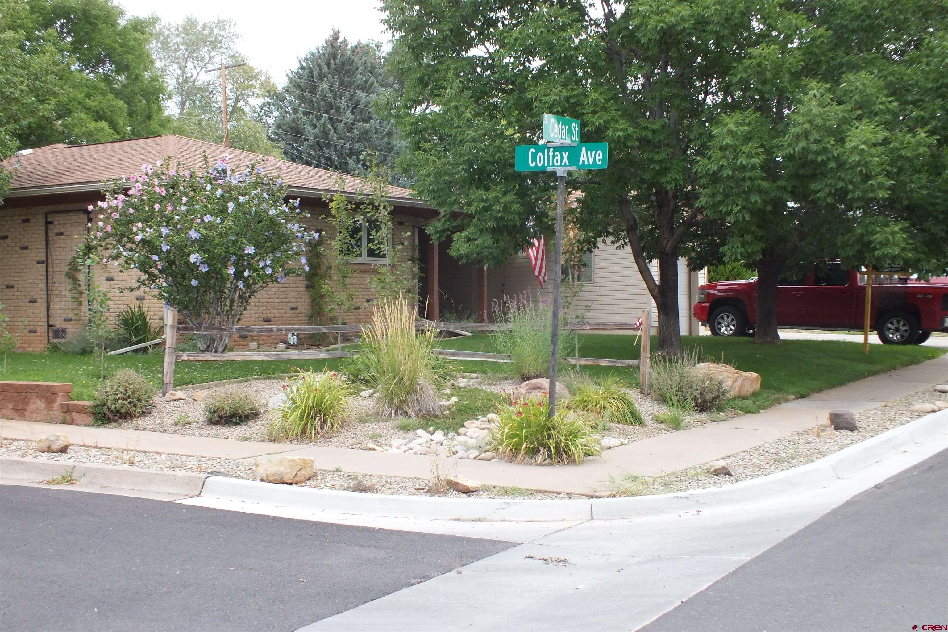 front view of house with a yard and potted plants