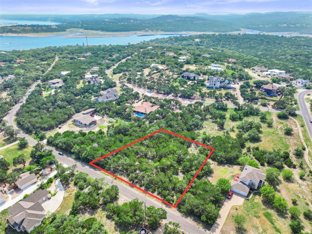 an aerial view of residential houses with outdoor space and trees