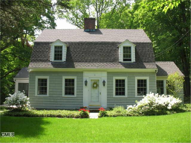 a front view of a house with a garden and plants