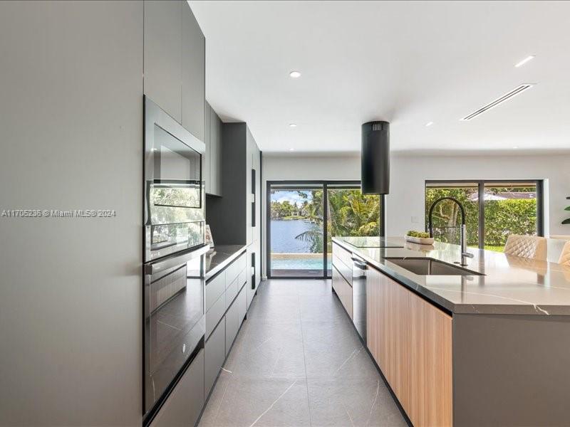 a kitchen with stainless steel appliances a sink and a large window