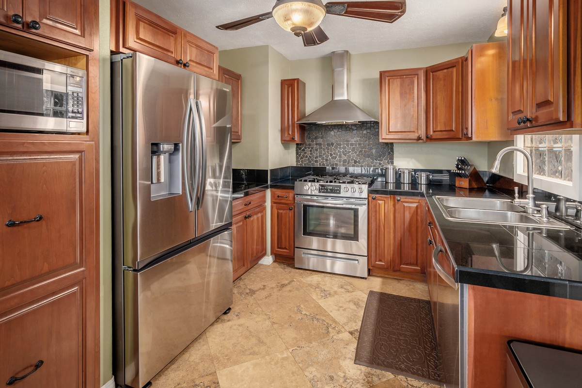 a kitchen with stainless steel appliances granite countertop a refrigerator a stove a sink and dishwasher