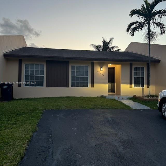 a front view of a house with a garden and yard