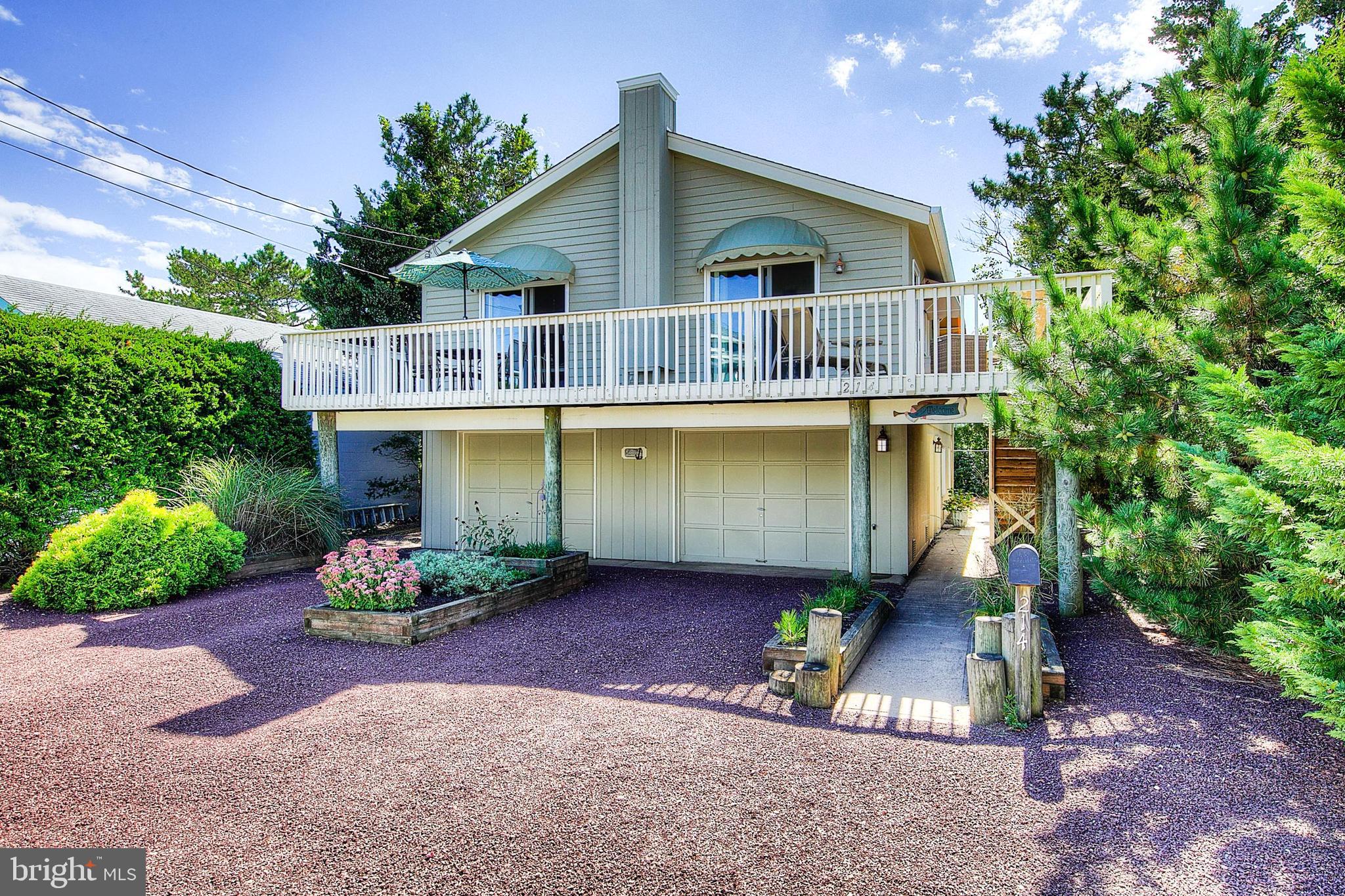 a front view of a house with a yard and potted plants