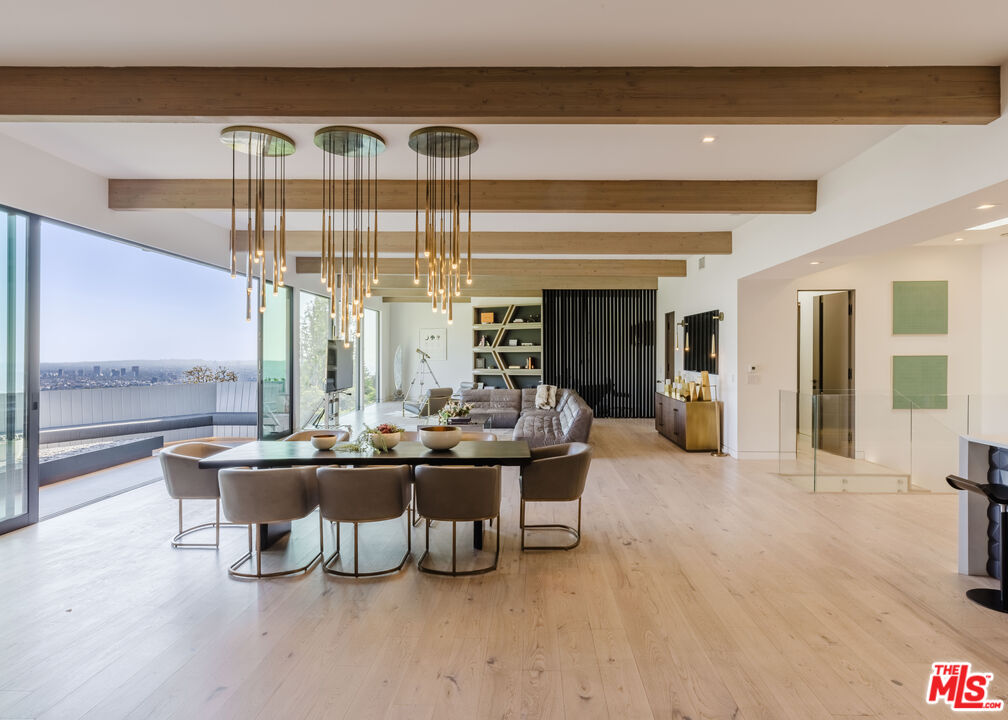 a living room with furniture a chandelier and a large window