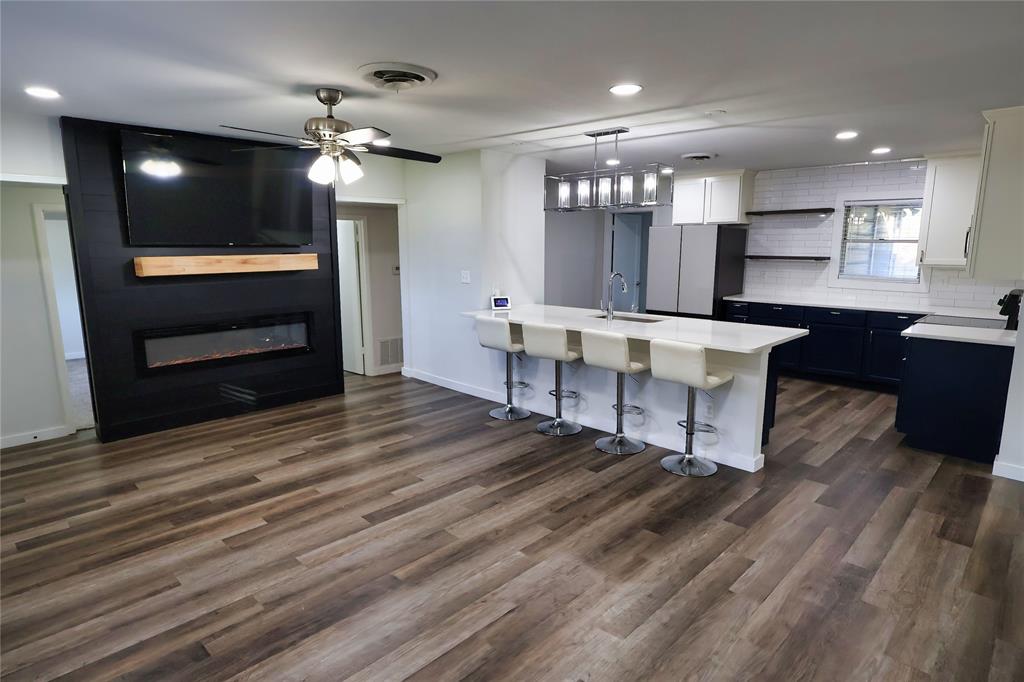 a view of kitchen with sink microwave and dining room